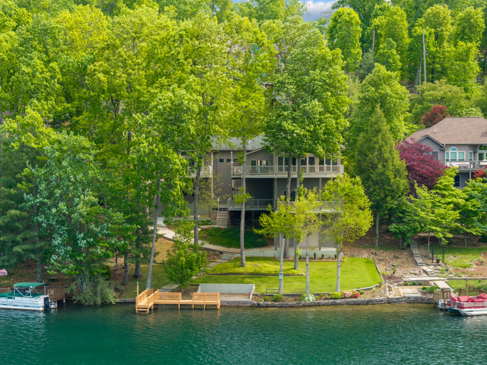 Lake-facing rear of home framed by mature trees